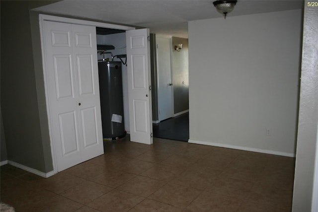 4720 Scots Briar Ln, Fort Worth, TX 76137 - unfurnished bedroom featuring water heater, baseboards, tile patterned flooring, and a closet