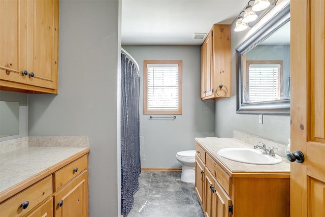bathroom featuring vanity, toilet, and baseboards