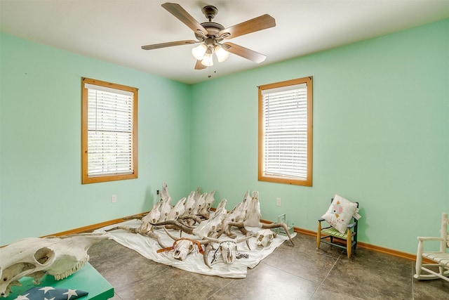 game room with baseboards and a ceiling fan