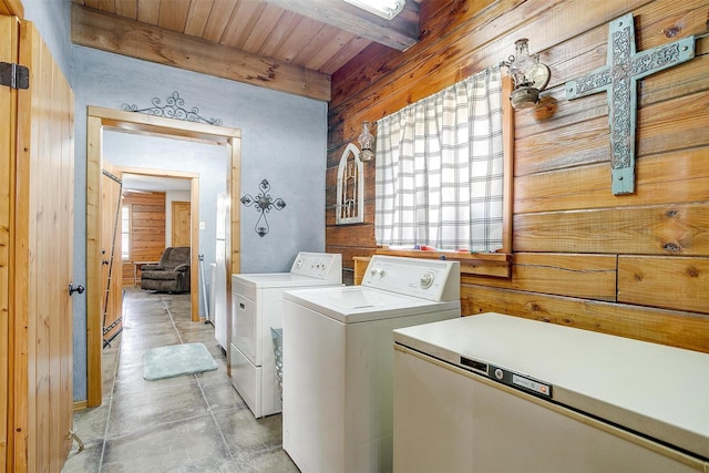 washroom with washing machine and dryer, wood walls, and wood ceiling