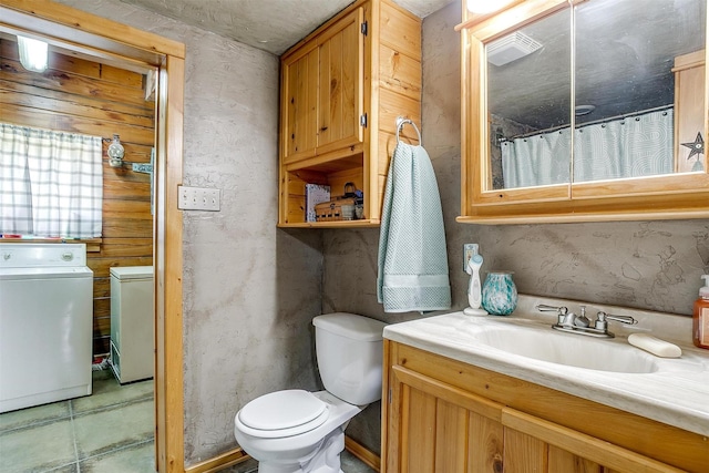 bathroom with washer and dryer, vanity, and toilet