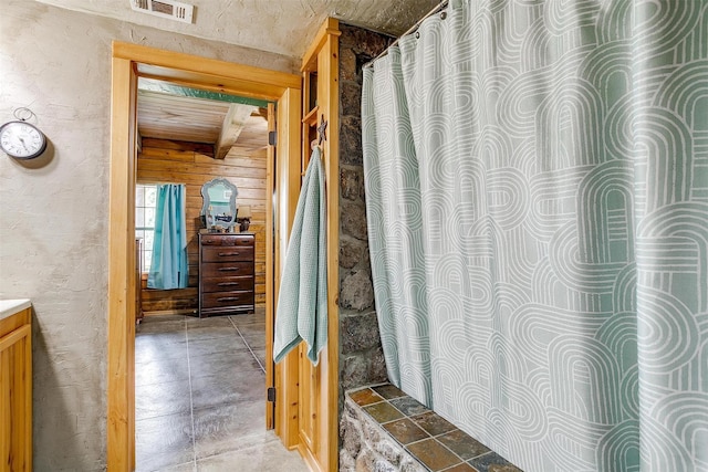 full bathroom with vanity and wooden walls