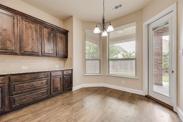 6809 Gallatin St, Mckinney, TX 75070 - kitchen featuring a chandelier, dark brown cabinets, dark wood-type flooring, and baseboards