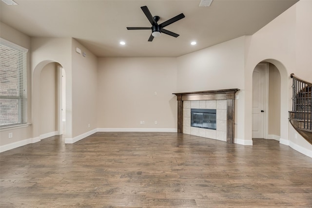 6809 Gallatin St, Mckinney, TX 75070 - unfurnished living room with ceiling fan, recessed lighting, wood finished floors, arched walkways, and a tile fireplace