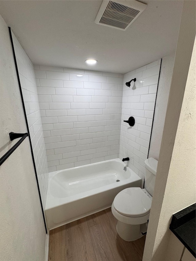 4859 Cedar Springs Rd Unit 150, Dallas, TX 75219 - full bath featuring wood finished floors, toilet, shower / washtub combination, and a textured wall
