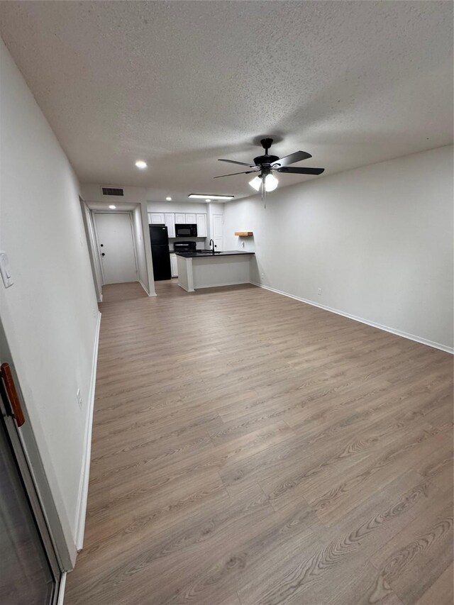 4859 Cedar Springs Rd Unit 150, Dallas, TX 75219 - unfurnished living room with a ceiling fan, baseboards, a textured ceiling, light wood-style floors, and recessed lighting