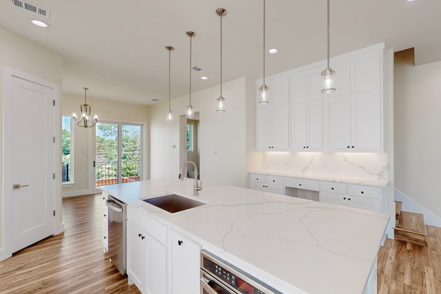 1021 Mobile St, Dallas, TX 75208 - kitchen with a sink, stainless steel dishwasher, light wood-type flooring, white cabinets, and hanging light fixtures