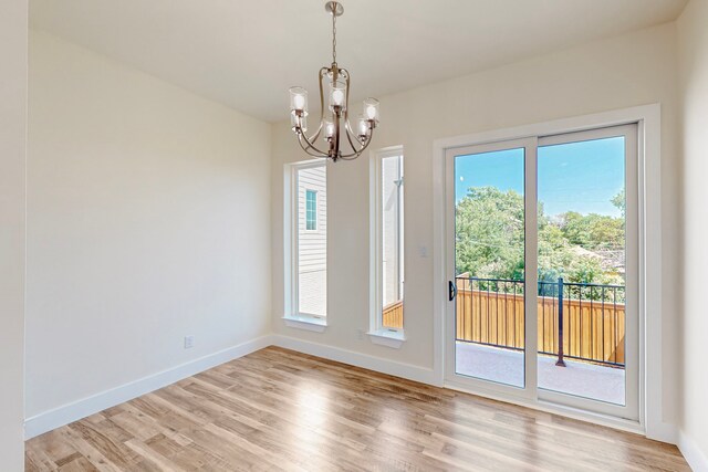 1021 Mobile St, Dallas, TX 75208 - unfurnished dining area with a chandelier, light wood-type flooring, and healthy amount of natural light