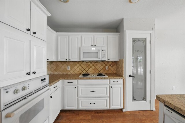 9228 Winslow Ct, North Richland Hills, TX 76182 - kitchen with white appliances, backsplash, white cabinets, and dark wood-type flooring