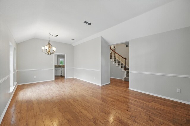 9228 Winslow Ct, North Richland Hills, TX 76182 - empty room with a chandelier, stairway, wood-type flooring, lofted ceiling, and baseboards