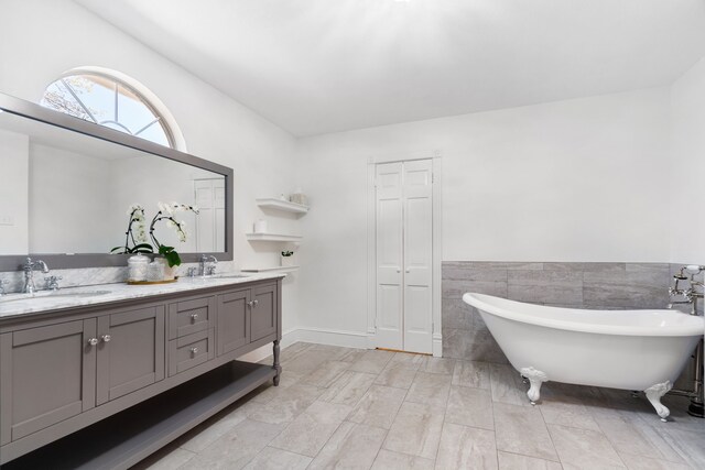 306 Stonecrest Rd, Argyle, TX 76226 - full bath featuring double vanity, a soaking tub, tile walls, and wainscoting