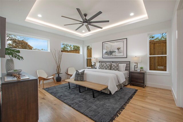 8506 Craighill Ave, Dallas, TX 75209 - bedroom featuring a raised ceiling, baseboards, light wood finished floors, recessed lighting, and a ceiling fan