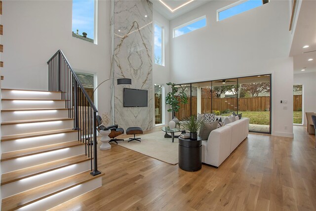 8506 Craighill Ave, Dallas, TX 75209 - living room featuring a towering ceiling, wood finished floors, healthy amount of natural light, and stairs