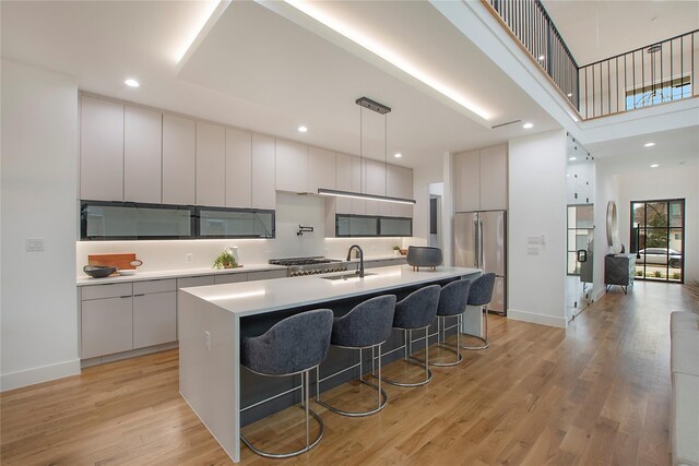 8506 Craighill Ave, Dallas, TX 75209 - kitchen featuring stainless steel refrigerator, modern cabinets, a breakfast bar area, recessed lighting, and a towering ceiling