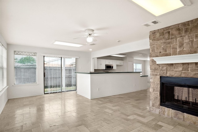 4629 Las Hadas, Mesquite, TX 75150 - unfurnished living room with ceiling fan, baseboards, and a fireplace