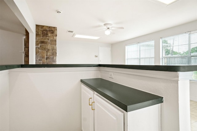 4629 Las Hadas, Mesquite, TX 75150 - kitchen featuring dark countertops, ceiling fan, and white cabinetry
