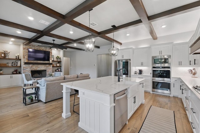 1020 Sky Rd, Weatherford, TX 76087 - kitchen with appliances with stainless steel finishes, coffered ceiling, tasteful backsplash, a ceiling fan, and a fireplace