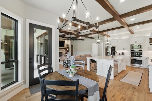 1020 Sky Rd, Weatherford, TX 76087 - dining area with coffered ceiling, a chandelier, a fireplace, beam ceiling, and light wood-type flooring