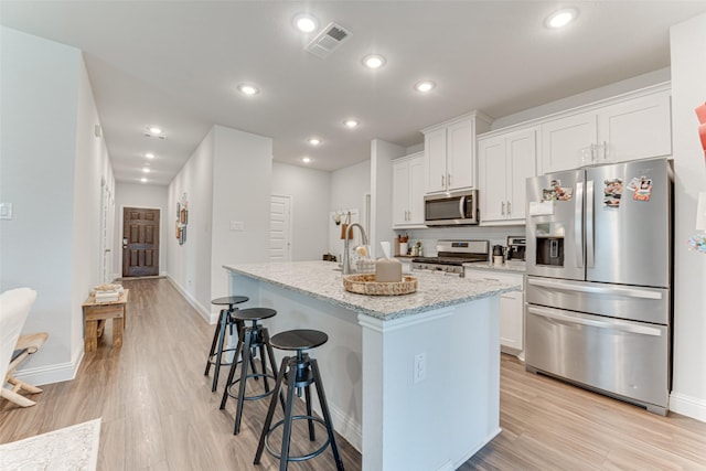 508 Vasant Dr, Royse City, TX 75189 - kitchen with appliances with stainless steel finishes, a kitchen island with sink, baseboards, a breakfast bar area, and recessed lighting
