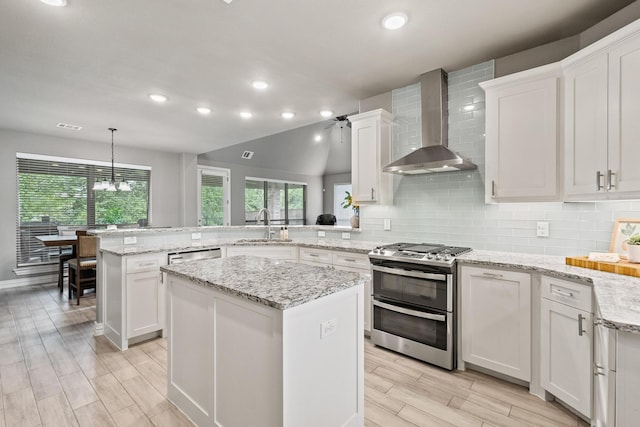 3723 Parkwood Ln, Denison, TX 75020 - kitchen with wall chimney exhaust hood, appliances with stainless steel finishes, a sink, a peninsula, and white cabinetry