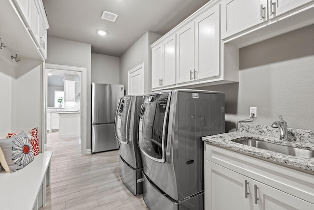 3723 Parkwood Ln, Denison, TX 75020 - washroom with a sink, washing machine and dryer, light wood-style floors, and recessed lighting
