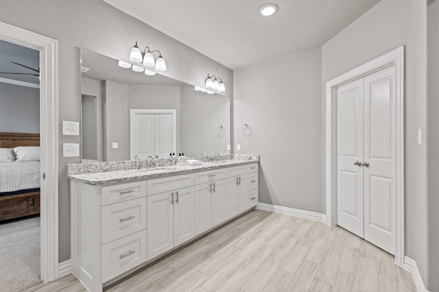 3723 Parkwood Ln, Denison, TX 75020 - ensuite bathroom with double vanity, wood finished floors, and baseboards