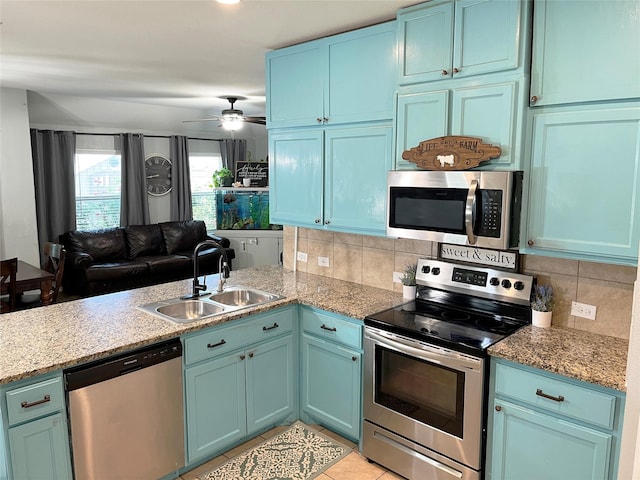 328 Foxhunter St, Fort Worth, TX 76131 - kitchen featuring appliances with stainless steel finishes, a sink, tasteful backsplash, blue cabinets, and a ceiling fan