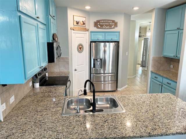 328 Foxhunter St, Fort Worth, TX 76131 - kitchen with stainless steel appliances, a sink, blue cabinetry, decorative backsplash, and stone counters