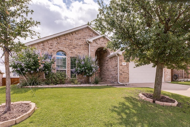 905 Ridge Dr, Little Elm, TX 75068 - view of front facade with driveway, brick siding, a front lawn, and a garage