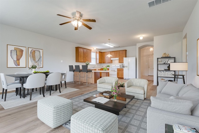 5132 Senator Dr, Fort Worth, TX 76244 - living area featuring light wood-style flooring, a ceiling fan, arched walkways, and baseboards