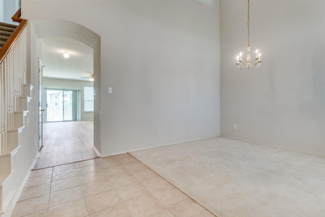 5132 Senator Dr, Fort Worth, TX 76244 - empty room with arched walkways, a ceiling fan, a chandelier, light tile patterned floors, and stairway