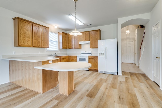 5132 Senator Dr, Fort Worth, TX 76244 - kitchen featuring white appliances, light wood finished floors, a peninsula, arched walkways, and light countertops