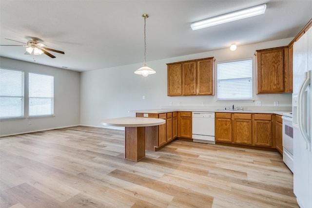 5132 Senator Dr, Fort Worth, TX 76244 - kitchen with white appliances, a peninsula, a sink, light countertops, and brown cabinetry