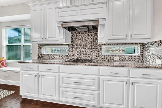 768 Telemark Trl, Frisco, TX 75036 - kitchen featuring stainless steel gas cooktop, ventilation hood, dark wood-style flooring, white cabinetry, and stone counters