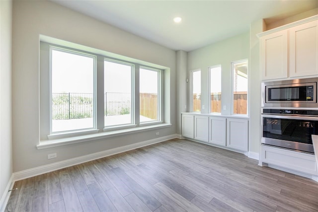 2207 Morris St, Rockwall, TX 75087 - kitchen featuring stainless steel appliances, healthy amount of natural light, baseboards, light wood-type flooring, and recessed lighting