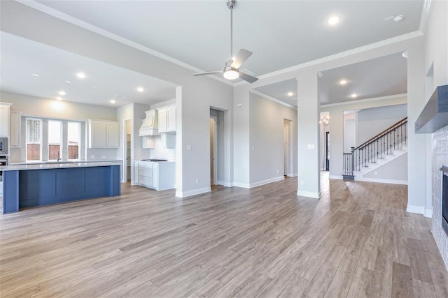 2207 Morris St, Rockwall, TX 75087 - unfurnished living room featuring light wood-style flooring, crown molding, baseboards, ceiling fan, and stairs