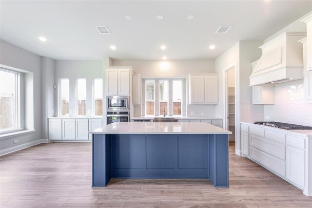 2207 Morris St, Rockwall, TX 75087 - kitchen with stainless steel appliances, a kitchen island, light countertops, white cabinetry, and recessed lighting