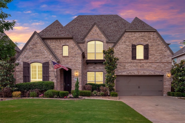1651 Old Oak Ct, Prosper, TX 75078 - french country inspired facade with brick siding, driveway, a yard, a shingled roof, and an attached garage
