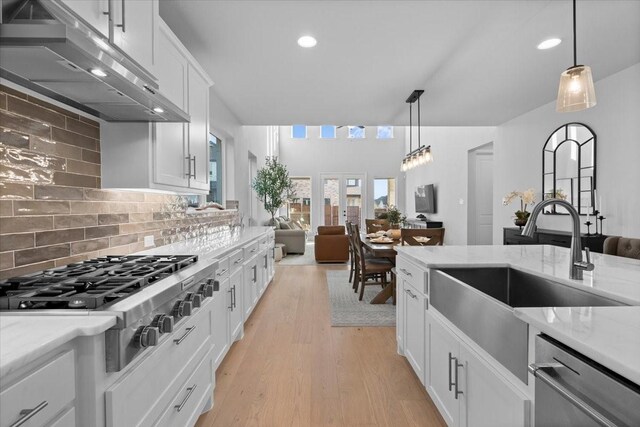 929 Lady Tessala Ave, Lewisville, TX 75056 - kitchen featuring appliances with stainless steel finishes, under cabinet range hood, a sink, open floor plan, and backsplash