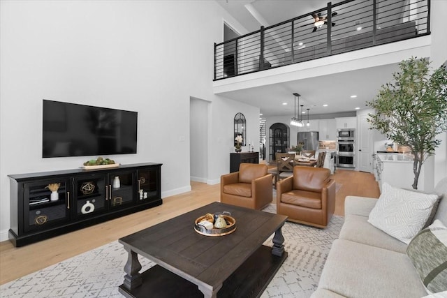 929 Lady Tessala Ave, Lewisville, TX 75056 - living area with light wood-type flooring, a towering ceiling, and baseboards