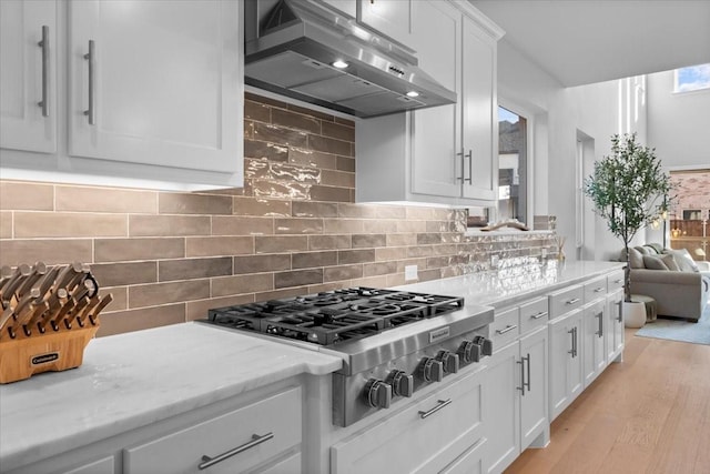 929 Lady Tessala Ave, Lewisville, TX 75056 - kitchen with exhaust hood, stainless steel gas cooktop, white cabinets, light wood-style flooring, and backsplash