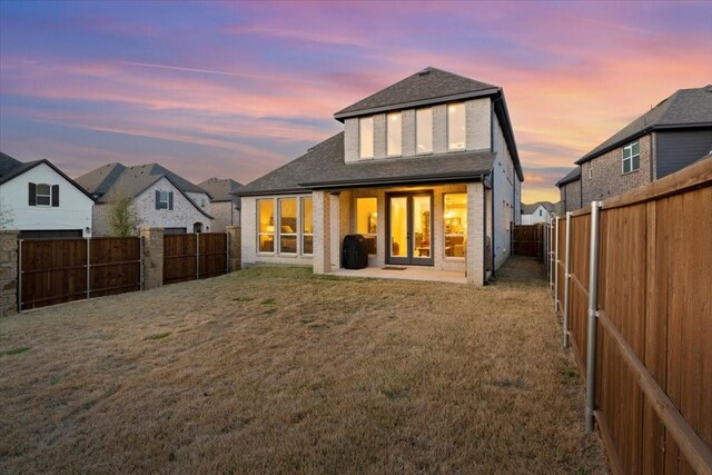 929 Lady Tessala Ave, Lewisville, TX 75056 - back of property at dusk with a shingled roof and a patio area