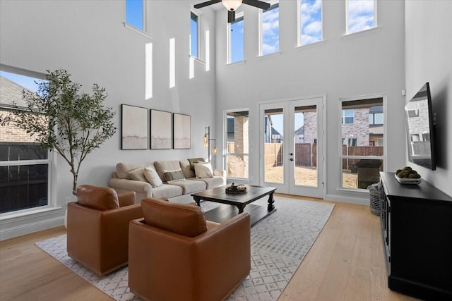 929 Lady Tessala Ave, Lewisville, TX 75056 - living area featuring a ceiling fan, french doors, light wood-style floors, a towering ceiling, and plenty of natural light