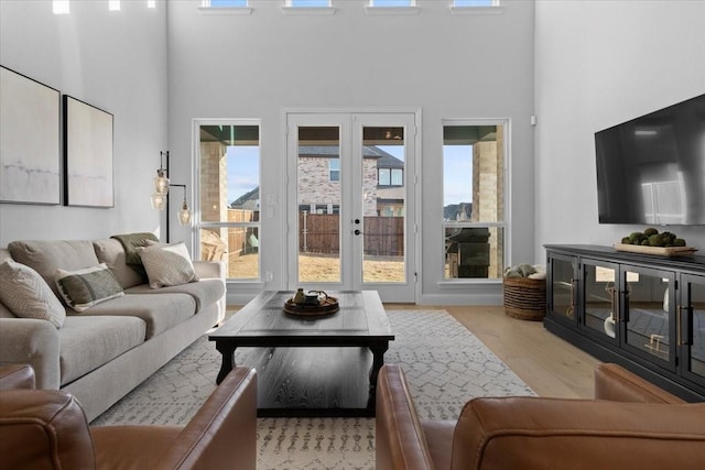 929 Lady Tessala Ave, Lewisville, TX 75056 - living area featuring a towering ceiling, wood finished floors, french doors, and healthy amount of natural light