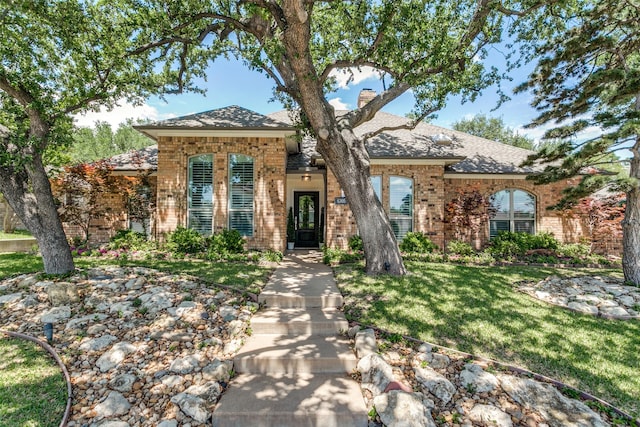 6305 Crested Butte Dr, Dallas, TX 75252 - view of front of house with brick siding, a front yard, a chimney, and a shingled roof