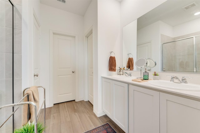 968 Manuel Dr, Fate, TX 75087 - bathroom featuring a stall shower, double vanity, and wood finished floors