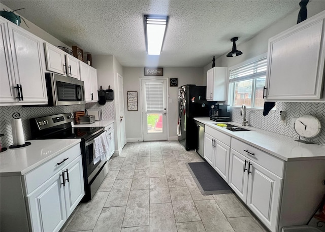 7208 Autumn Run Dr, Forest Hill, TX 76140 - kitchen featuring stainless steel appliances, a sink, backsplash, a textured ceiling, and white cabinetry