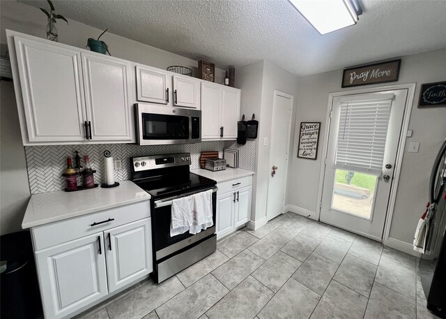 7208 Autumn Run Dr, Forest Hill, TX 76140 - kitchen featuring stainless steel appliances, a textured ceiling, backsplash, white cabinets, and light countertops