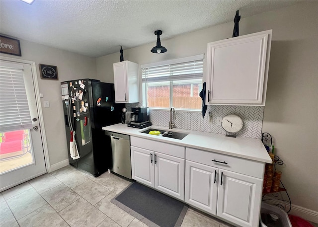 7208 Autumn Run Dr, Forest Hill, TX 76140 - kitchen featuring a sink, stainless steel dishwasher, black fridge, tasteful backsplash, and a textured ceiling