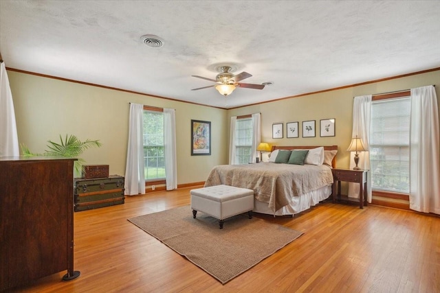 3808 Huaco Ln, Waco, TX 76710 - bedroom with crown molding, light wood-style flooring, a ceiling fan, and baseboards